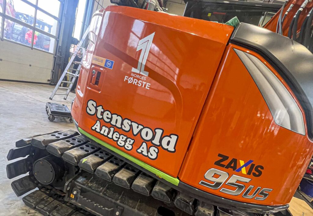 Oransje gravemaskin Stensvold Anlegg